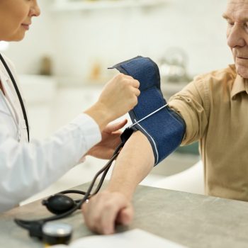 Aged man with manometer cuff around his arm